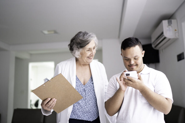 Female doctor with clipboard talking with man who is on his phone