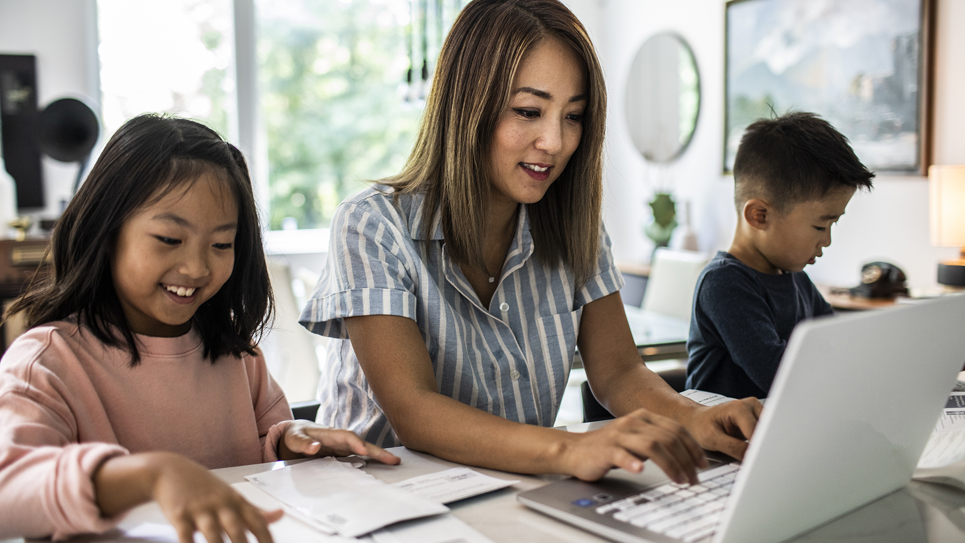 Mother working from home surrounded by children