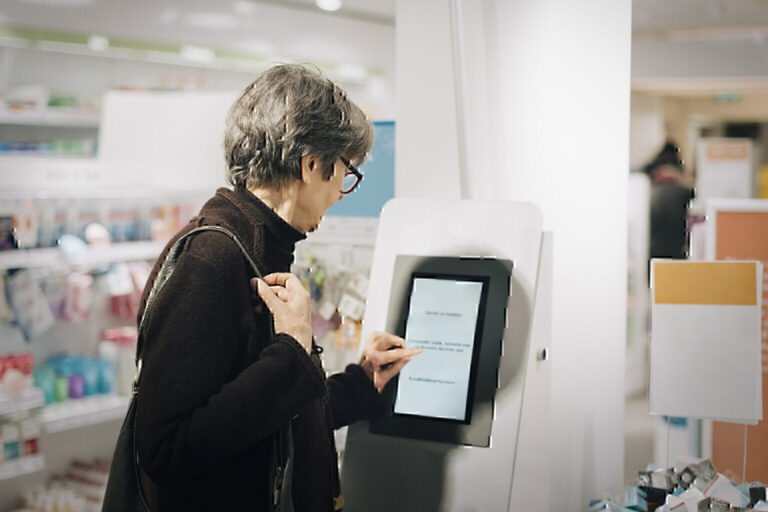 Woman using kiosk at pharmacy store