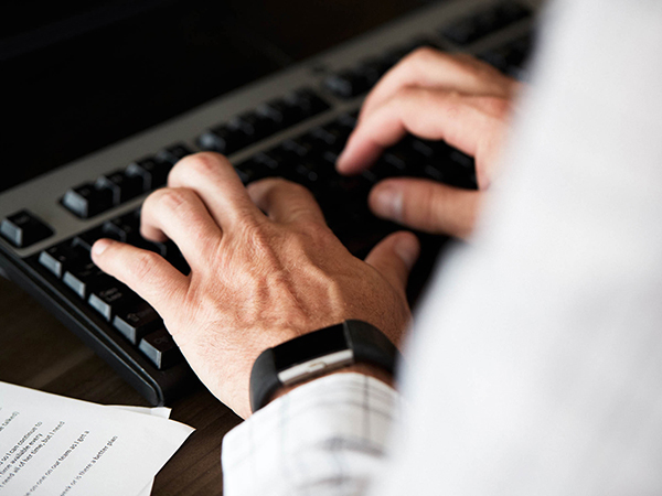 hands typing on a keyboard