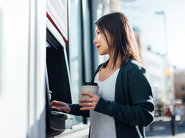 Young Woman Withdrawing Cash Money At The ATM