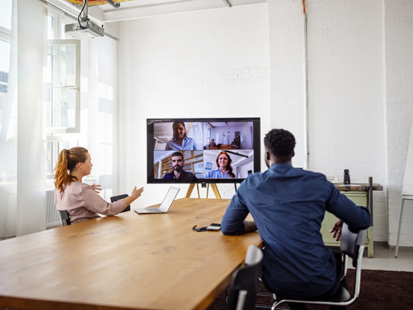 Businesspeople having a video conference in office. Business men and women having a web conference in office board room.