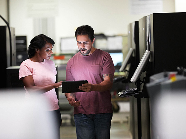 couple using tablet together walking through company