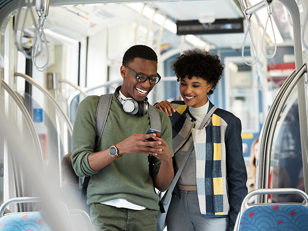 couple on light rail looking at phone