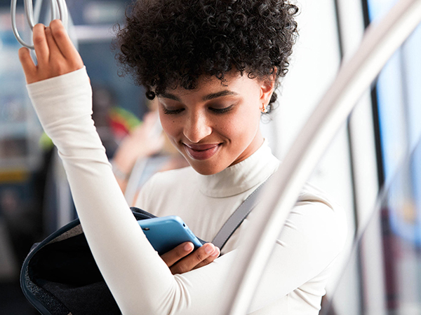 woman on light rail looking at phone