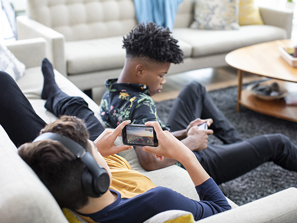 Children playing video games on a couch.