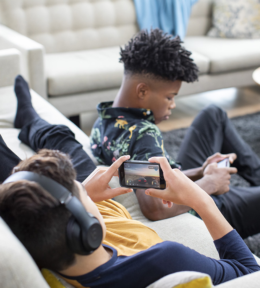 Children playing video games together on a couch.