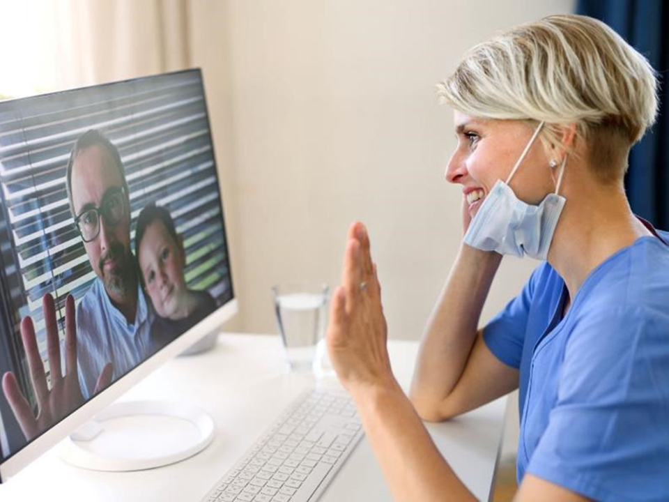 Female doctor having a video call with patients on her laptop.