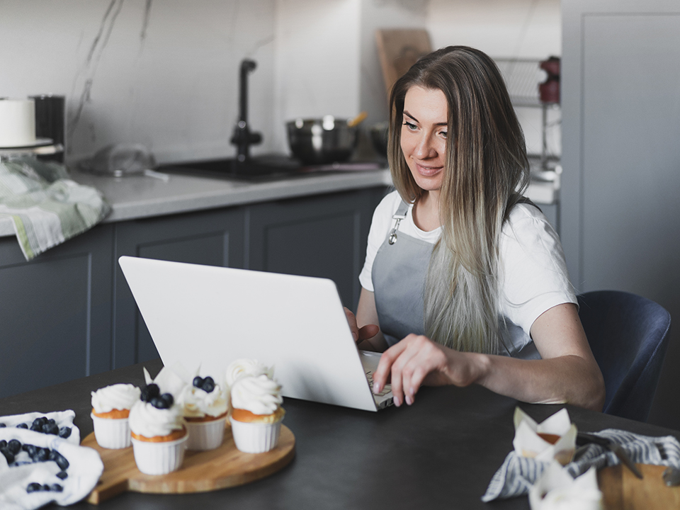 Young woman on laptop in kitchen