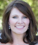 Professional portrait of a smiling woman with long brown hair.