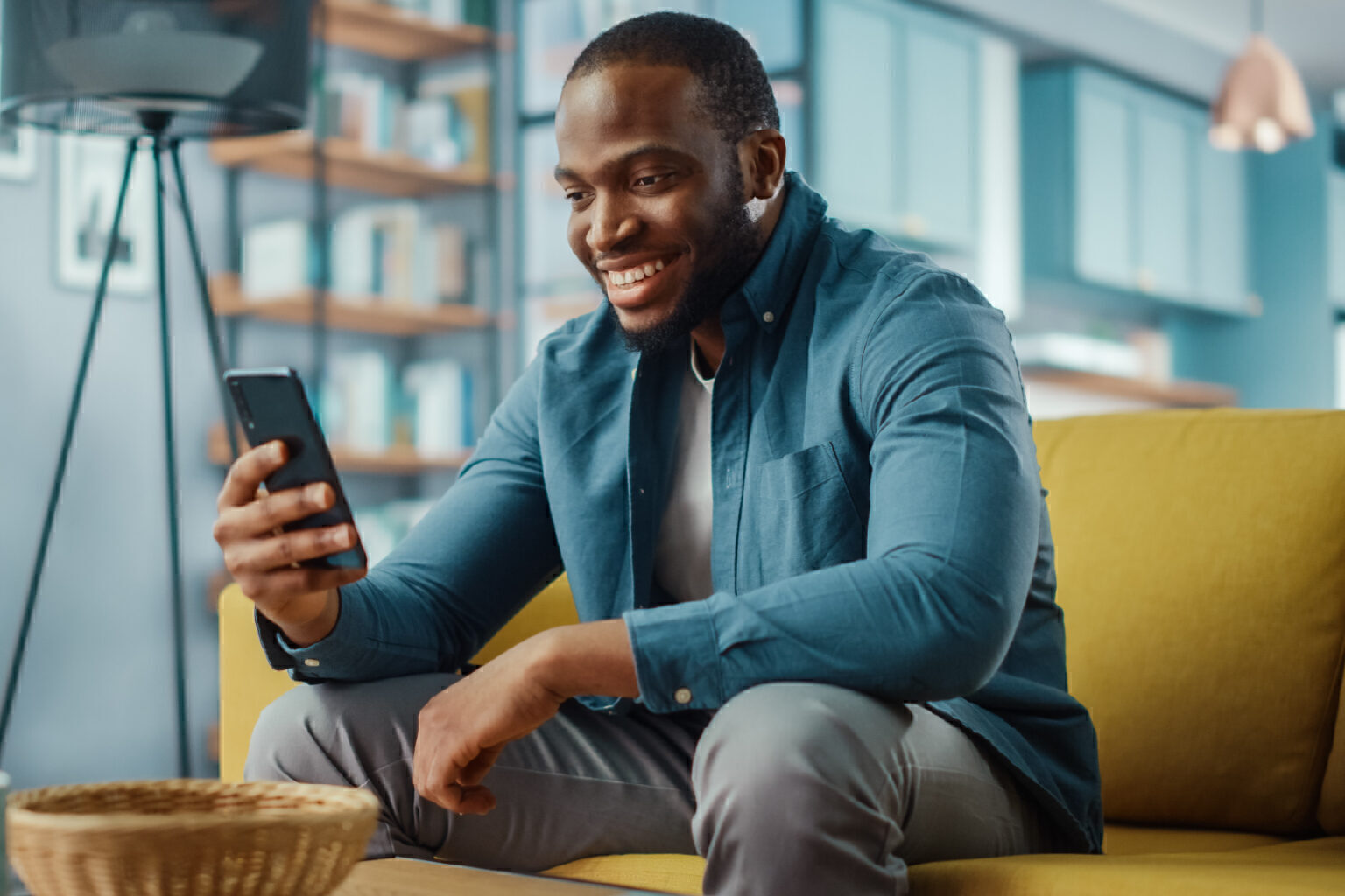 man on couch looking at phone