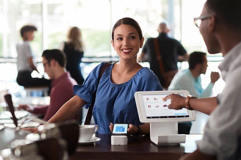 Happy Customer Making Mobile Payment at Cafe
