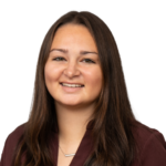 Smiling woman with long hair wearing a maroon top.