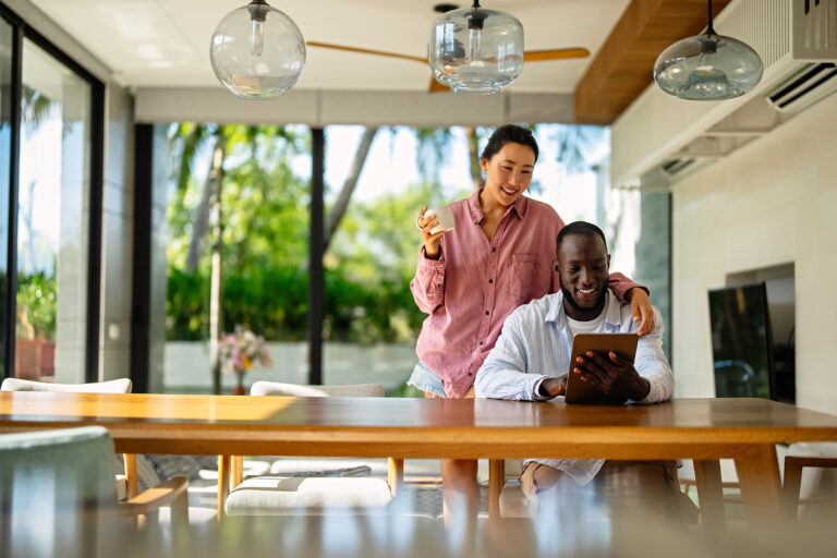 A happy, multi-national couple who are digital nomads and work from a different country every month