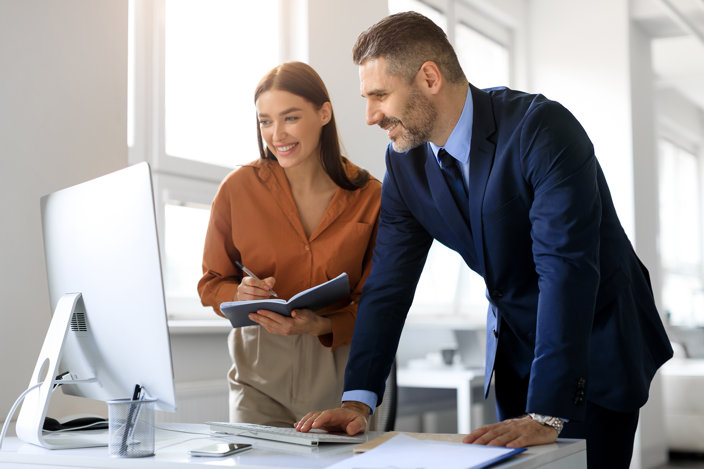 Business colleagues using computer and communicating, working on business project together