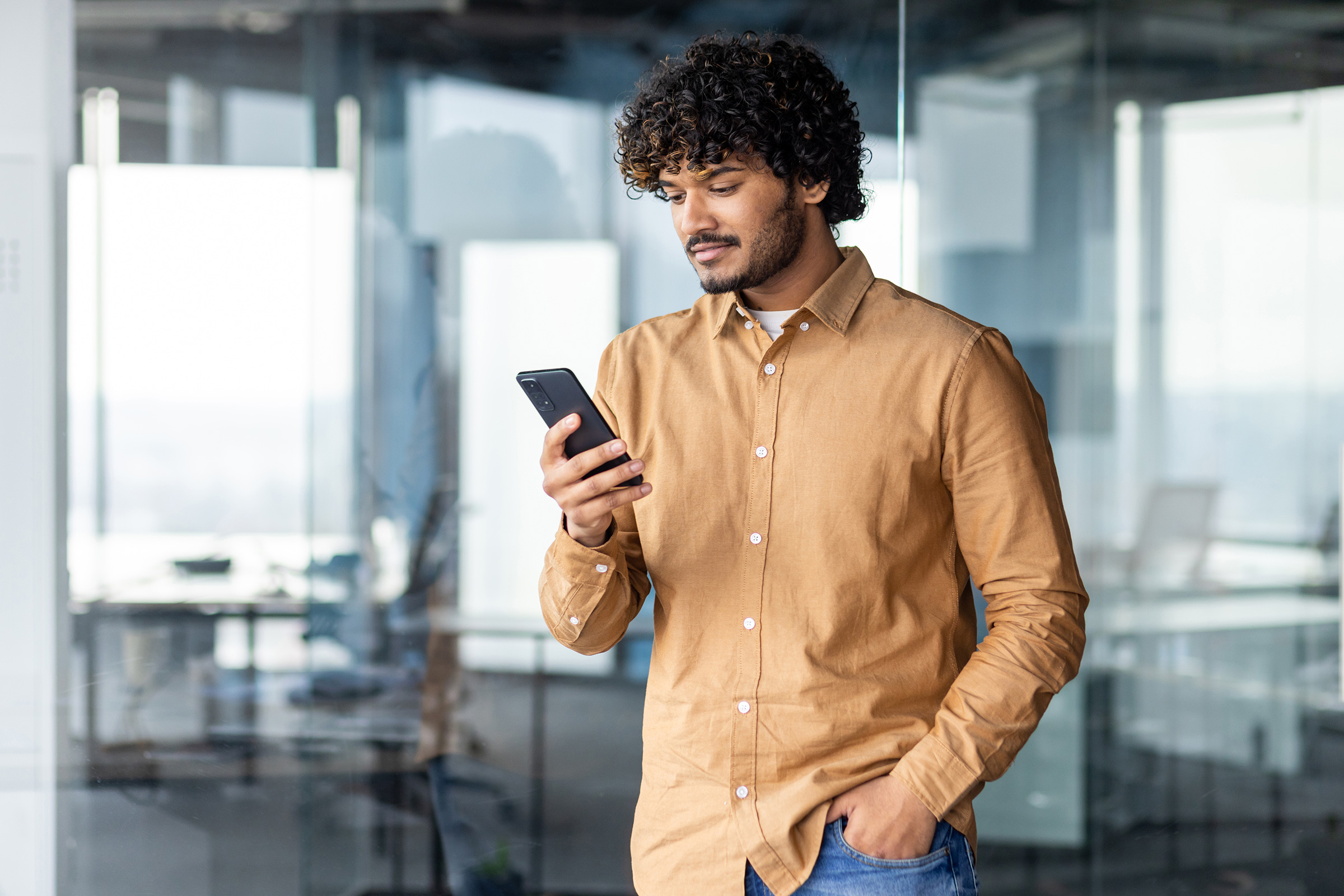 Young business man uses his phone in the office