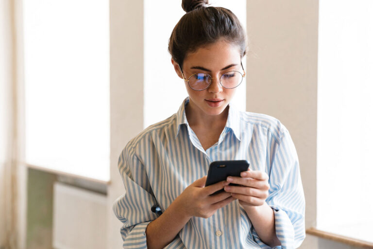 Business woman in office checking phone messages