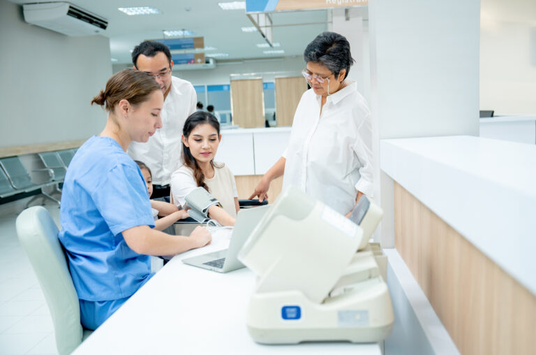 caucasian nurse measure blood pressure of asian women