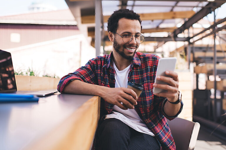 cheerful hipster guy browsing web content in social networks using 4g internet