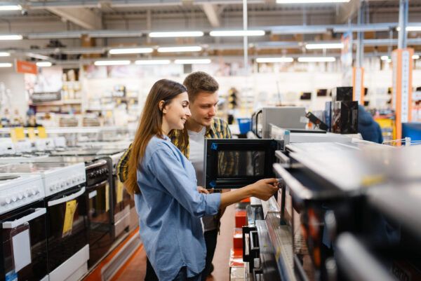 couple shopping in store for microwaves