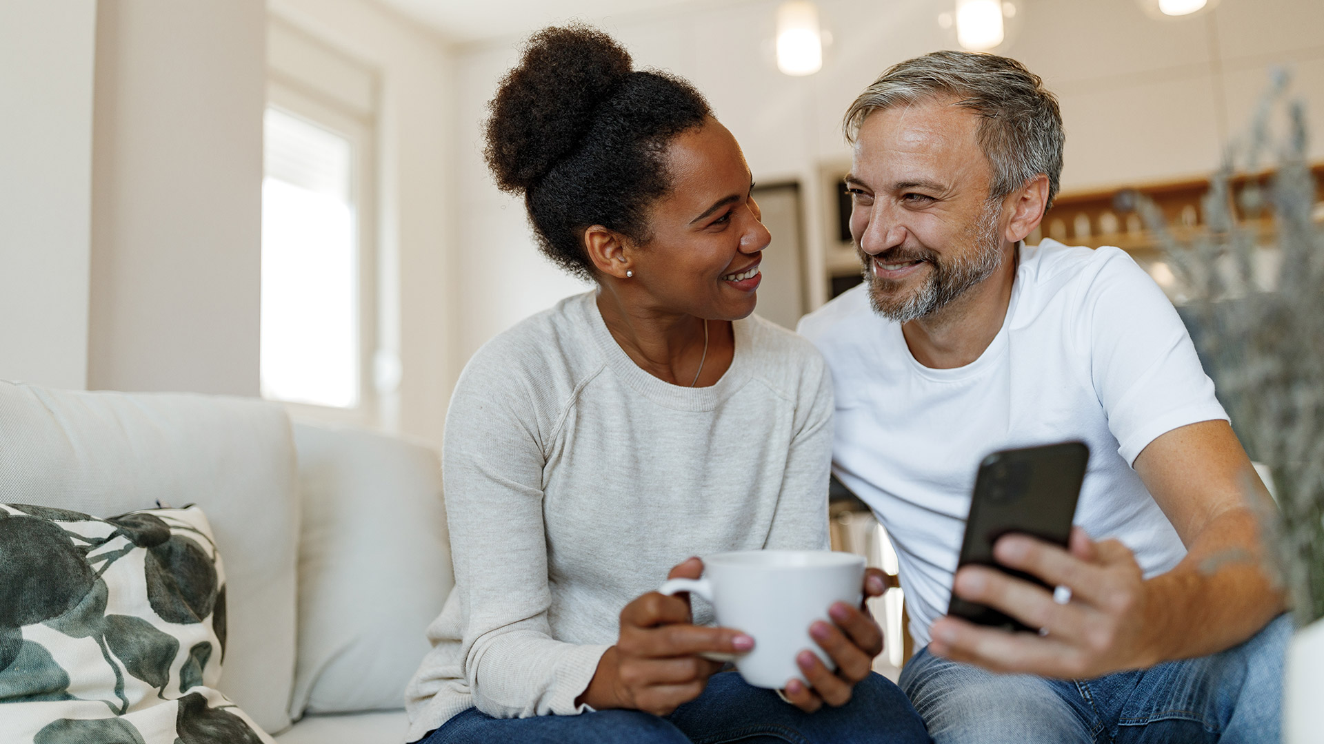 Mature couple on couch sharing phone