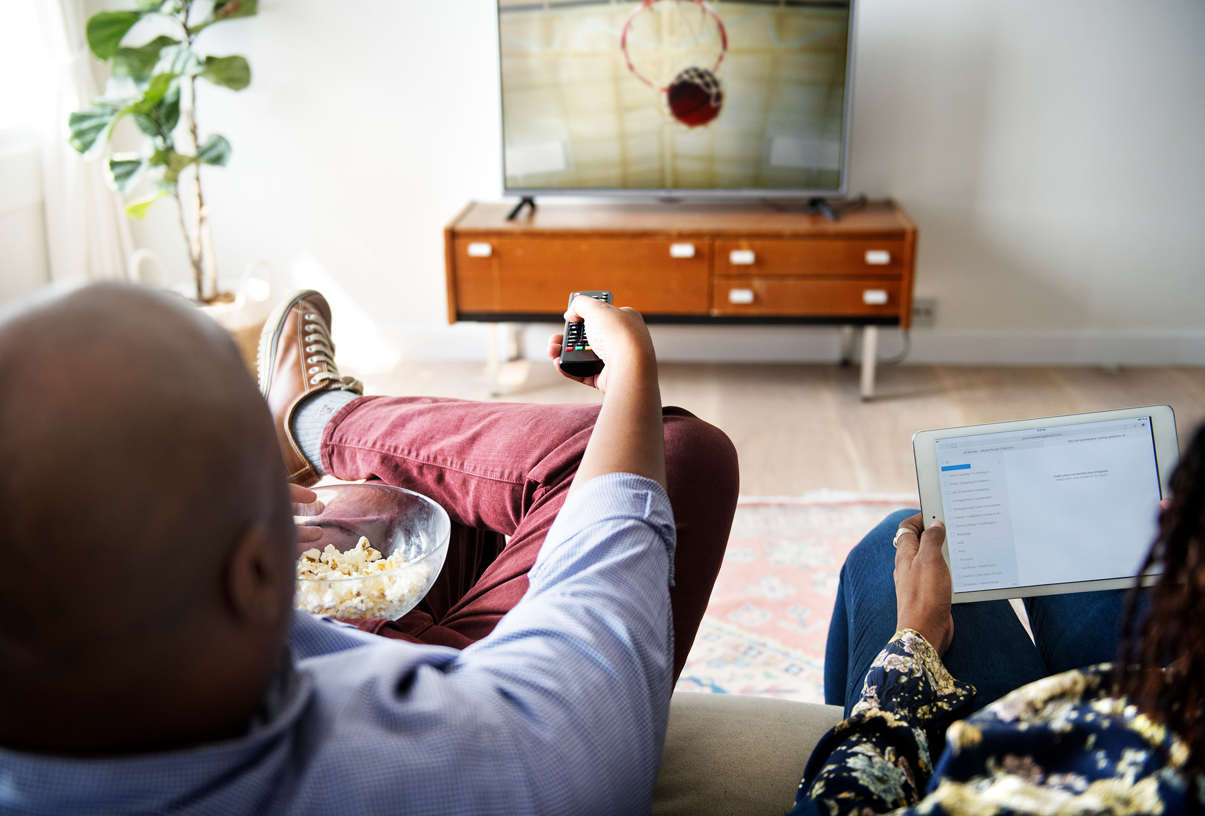 Couple watches basketball game together at home