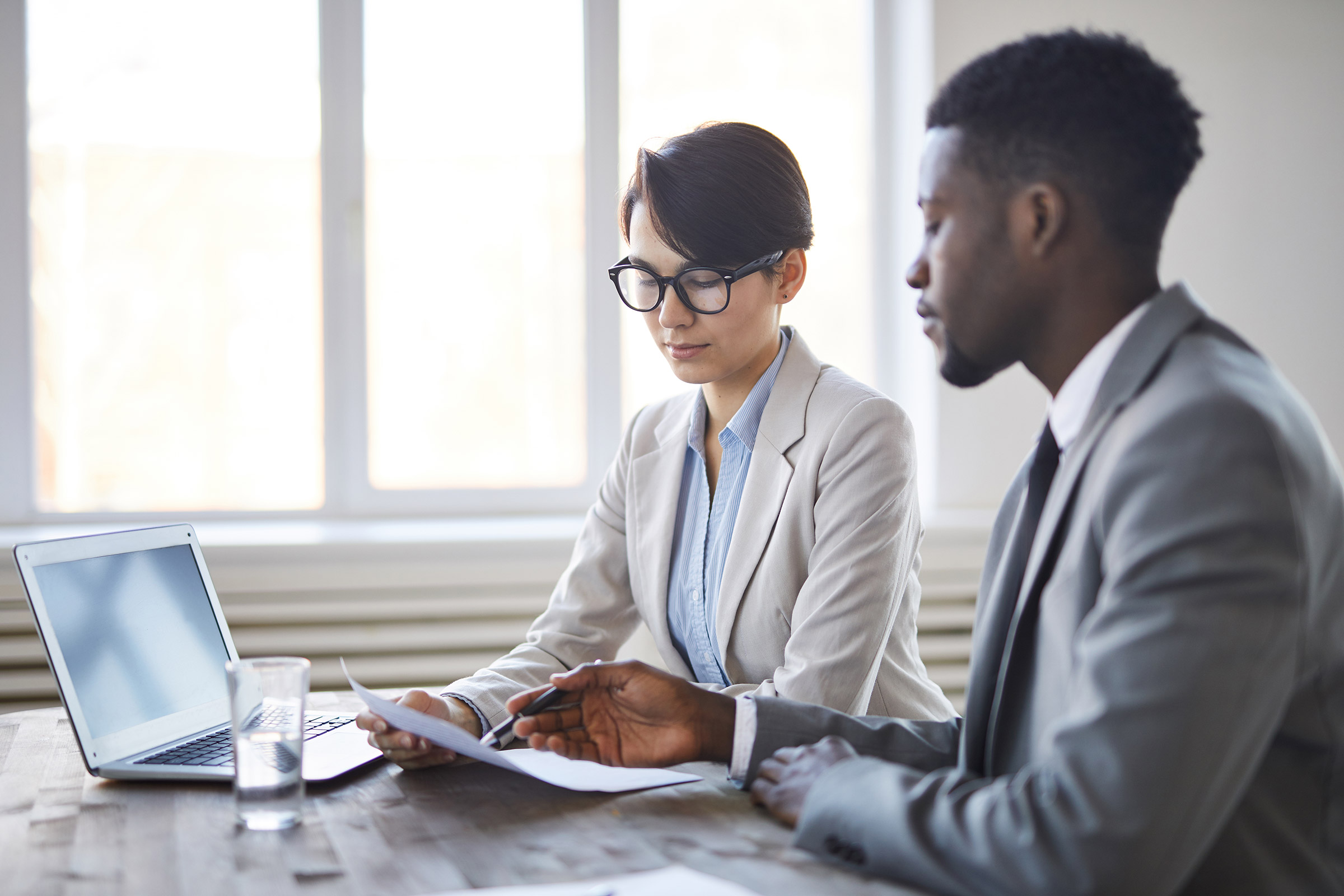 Two colleagues review a document