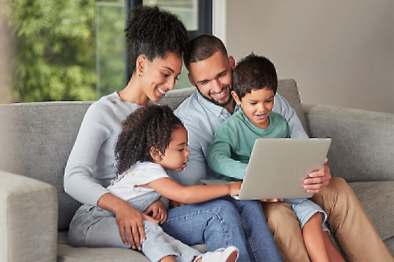 family looking at laptop on sofa