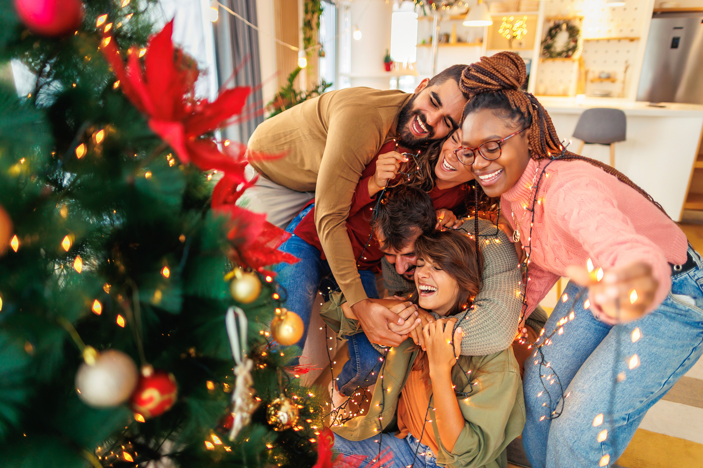 friends having fun decorating christmas tree