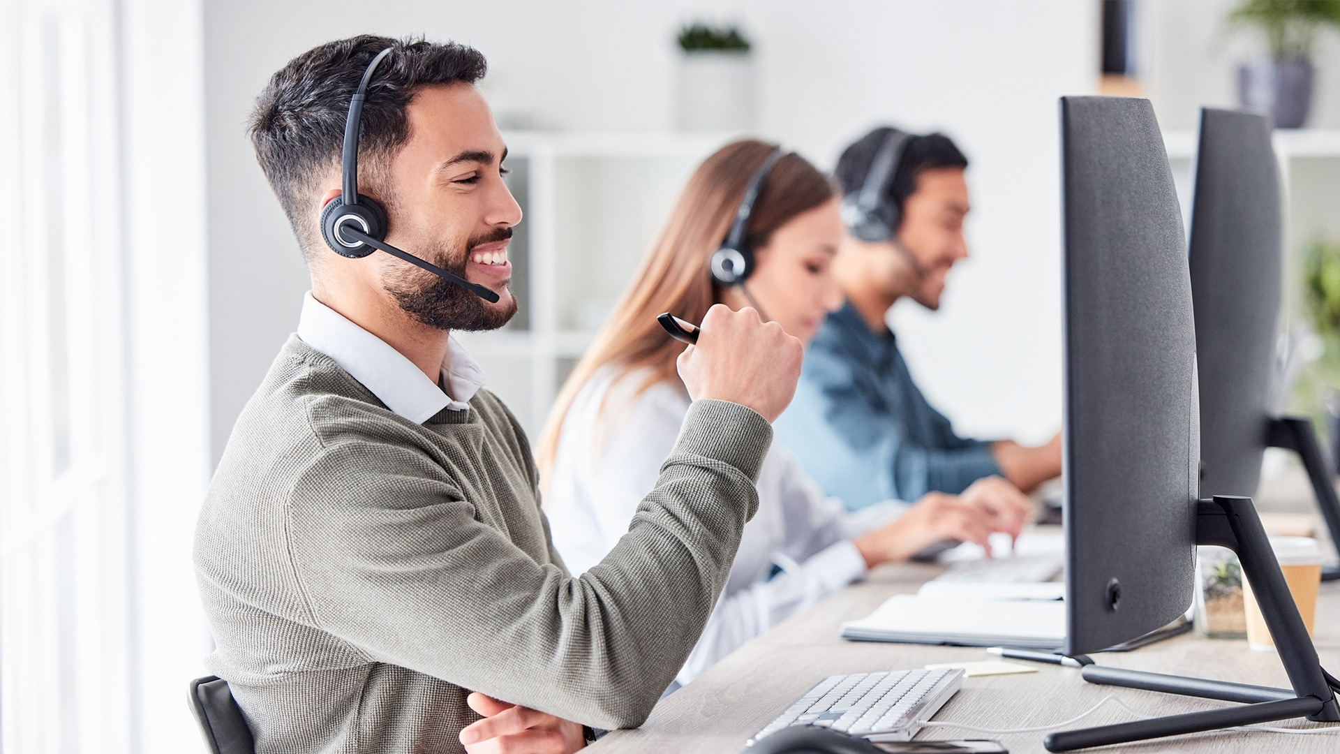 Handsome call center agent helps a customer with a smile