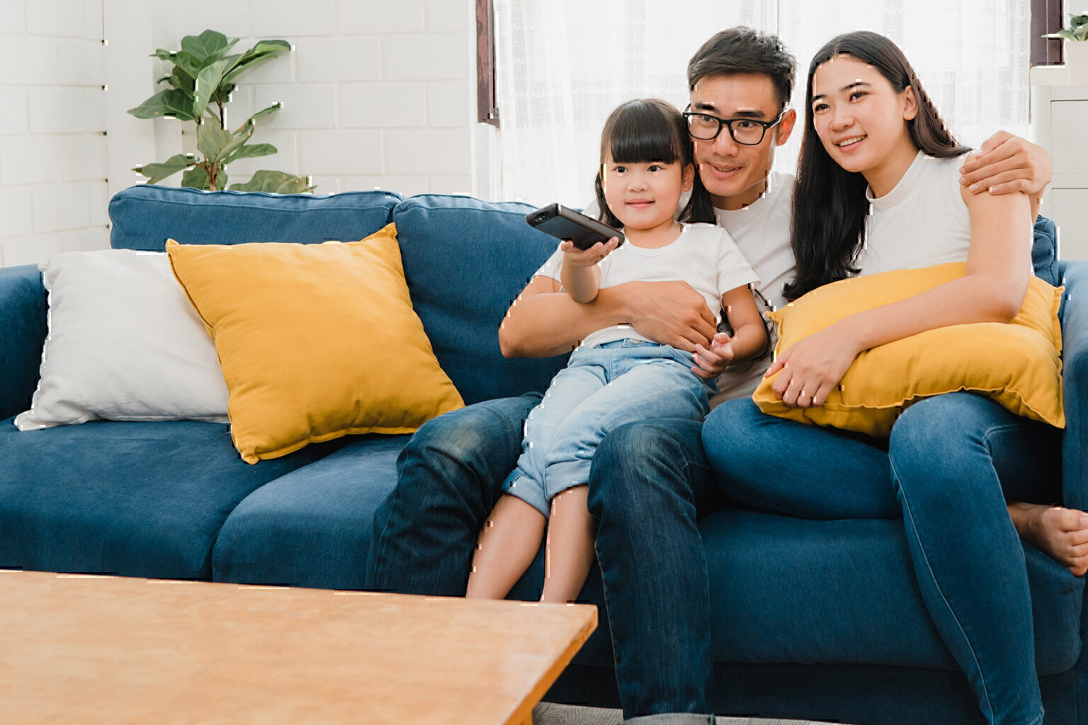 Happy Asian family watches tv together