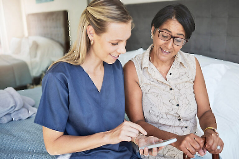 Happy nurse helps elderly patient with phone