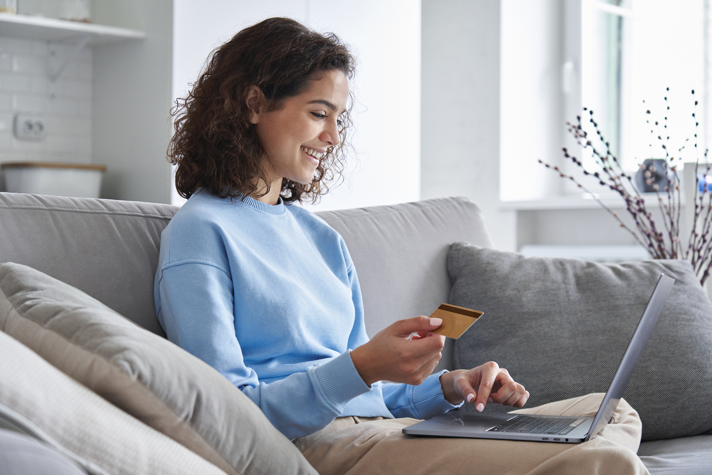 happy young woman consumer holding credit card and smiling