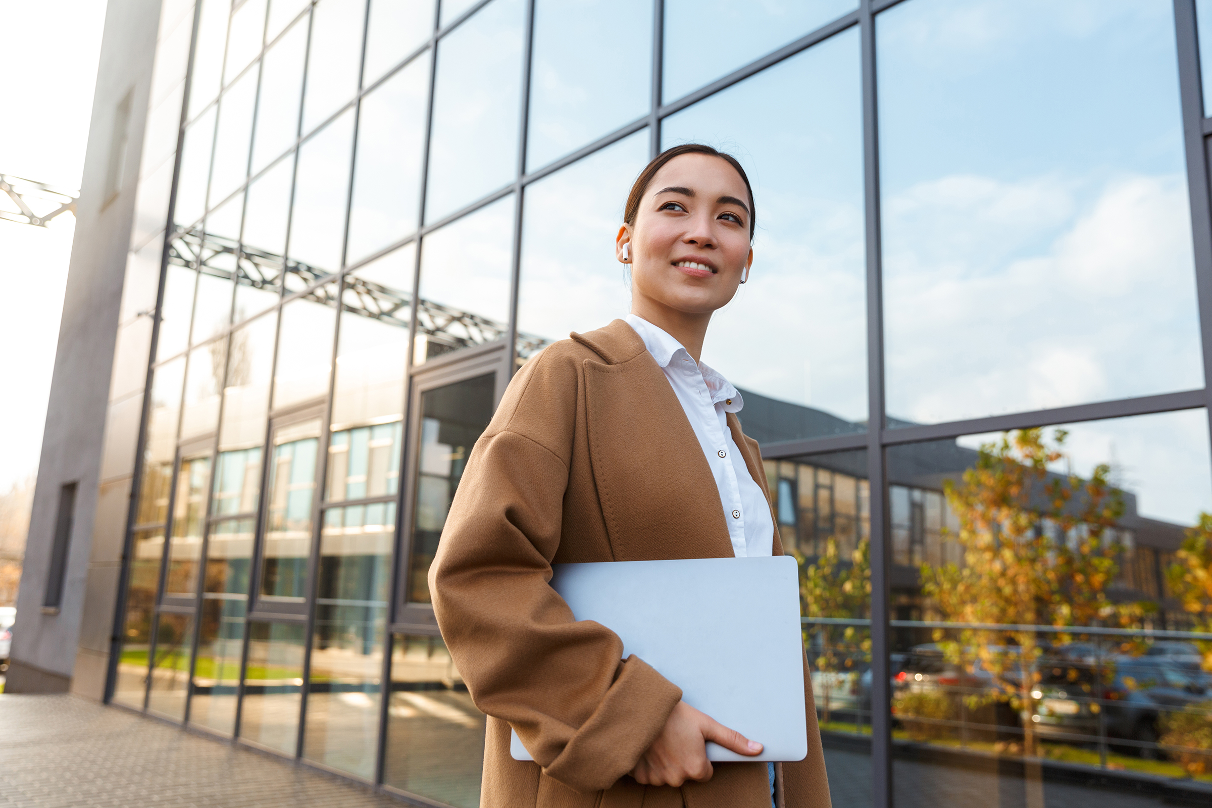 image of young brunette asian woman holding laptop