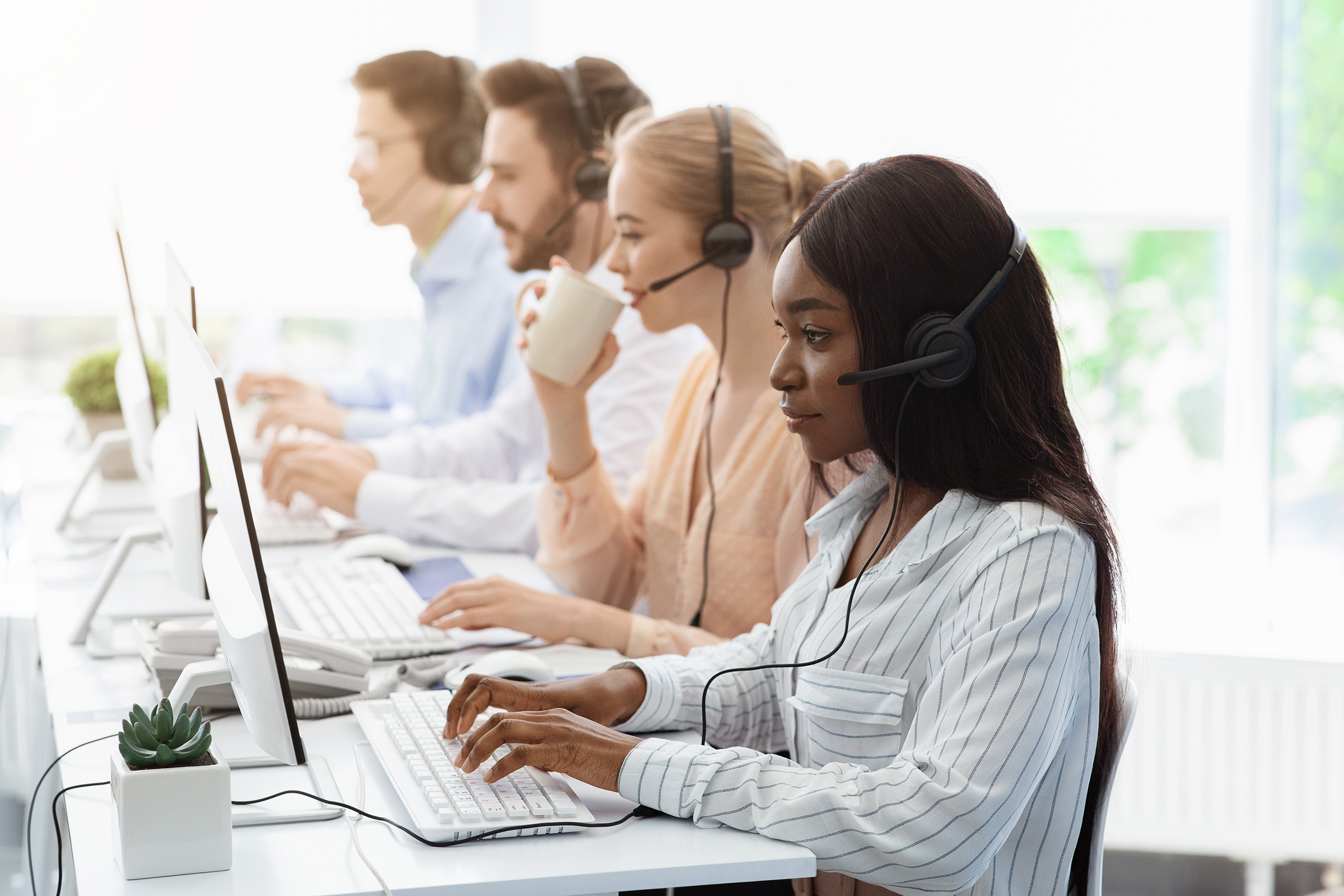 line of call center employees with headphones