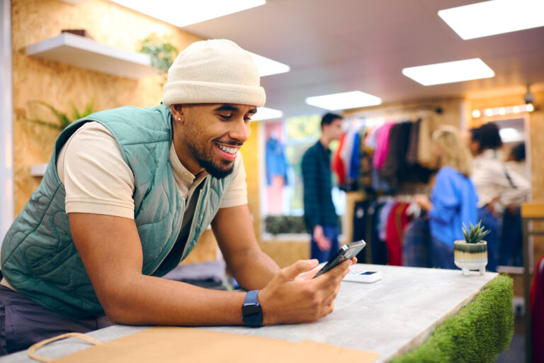 male sales assistant at cash desk in popup fashion shop