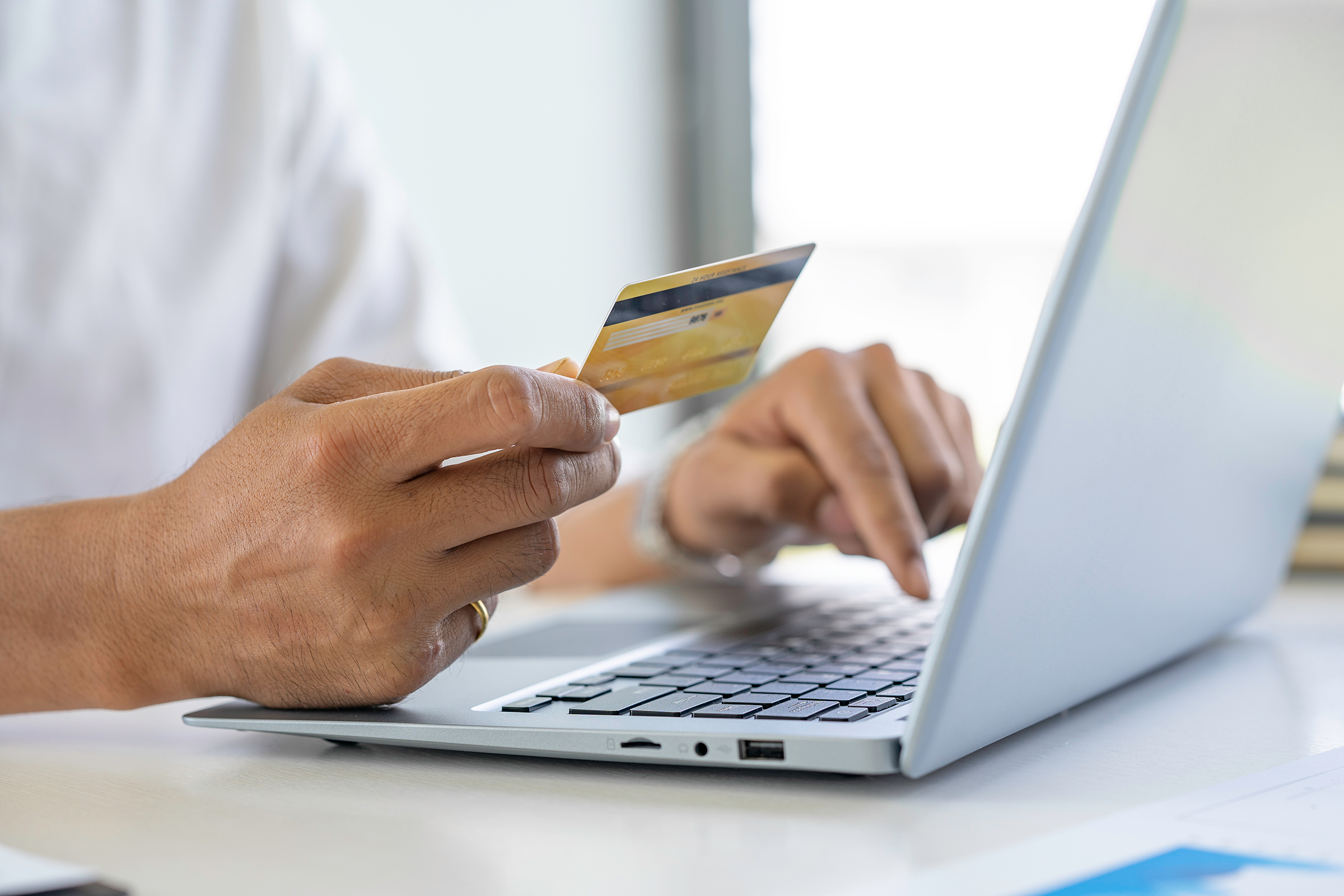 man shopping online with a credit card and laptop