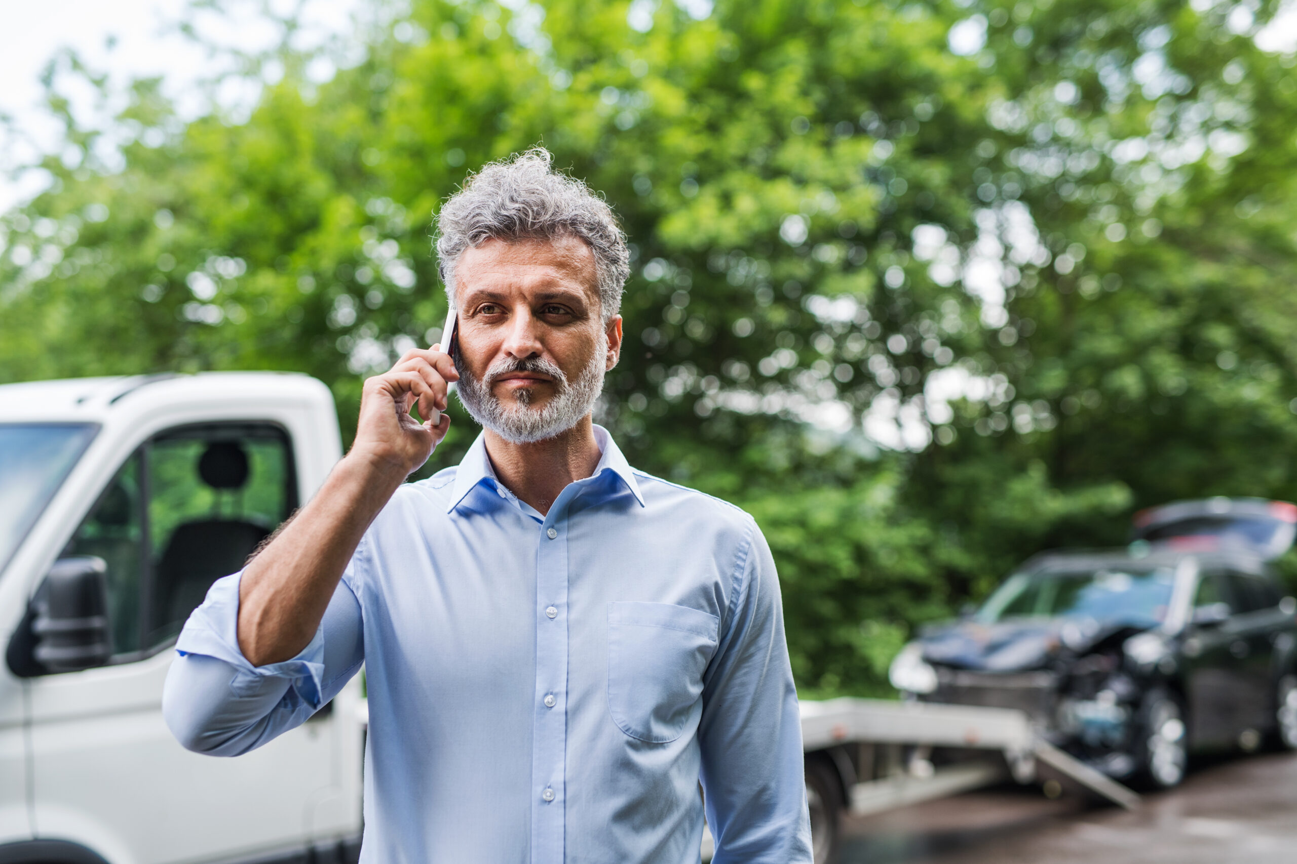 Man making a phone call after a car accident