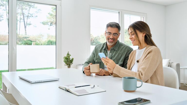 Middle aged couple using mobile banking at home