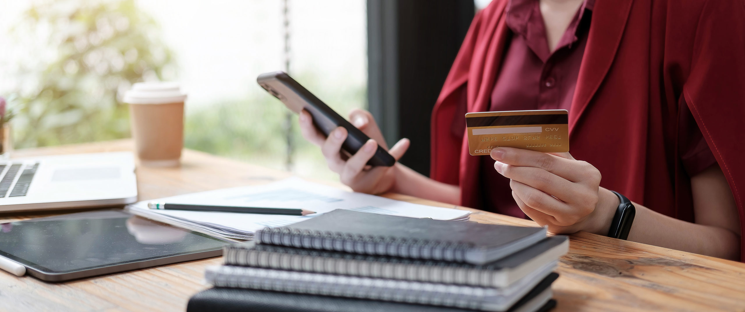 Selective focus on a woman's hands holding a smartphone and a credit card for online shopping.