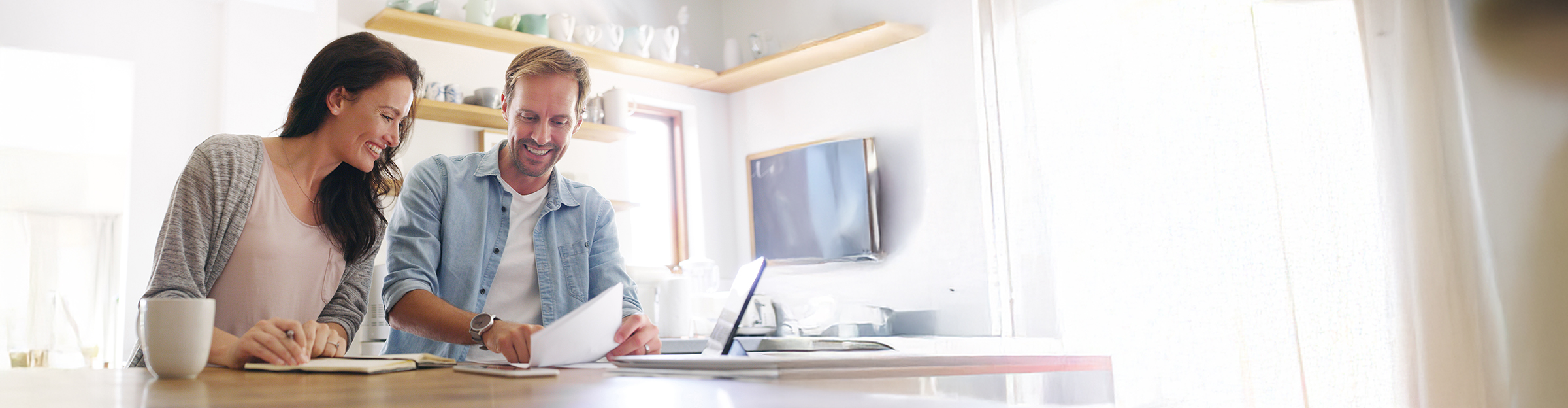 Couple, paperwork and laptop with budget in home for mortgage loan, investment planning or bills.
