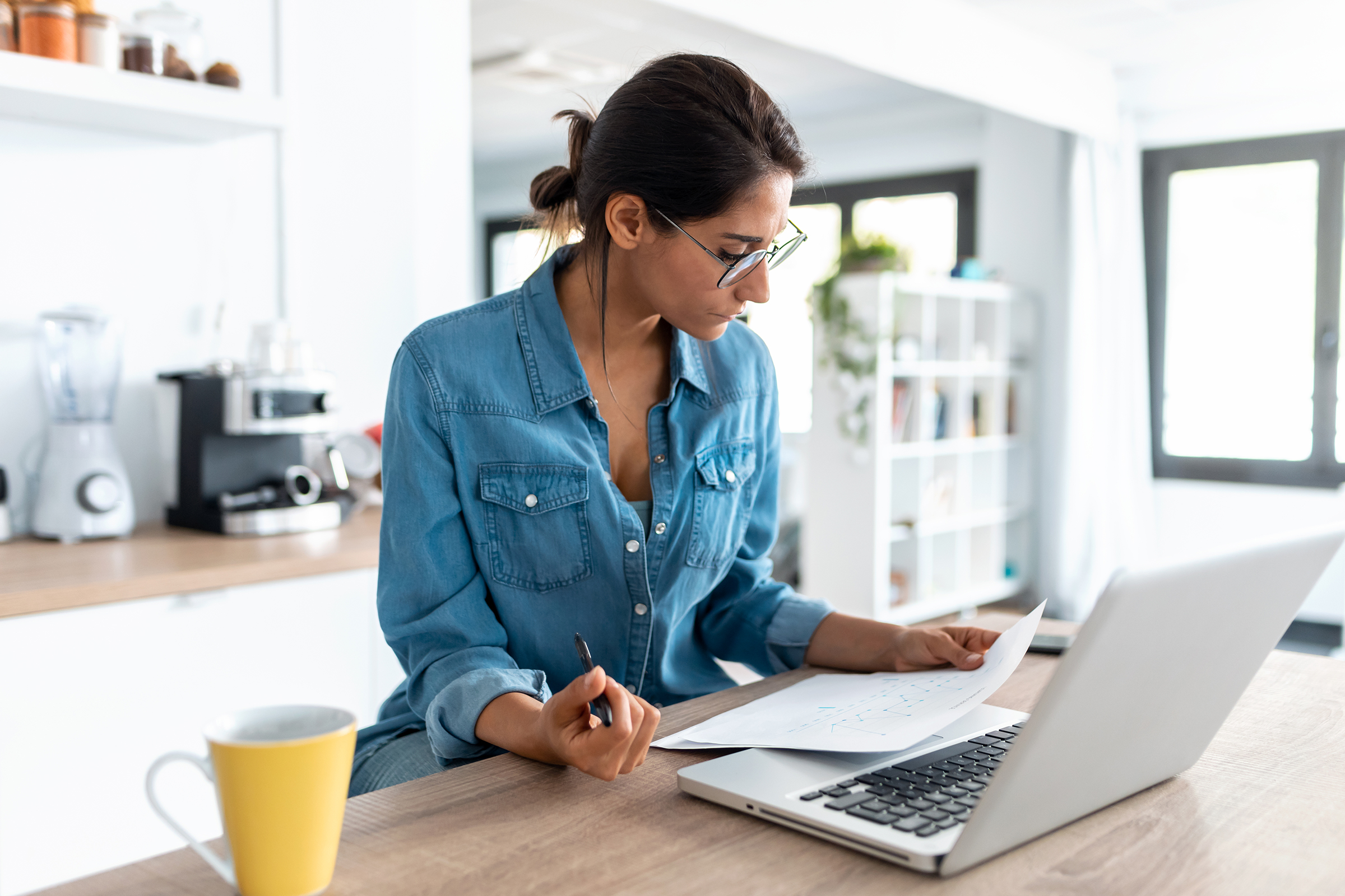 pretty young woman reviewing paperwork and working
