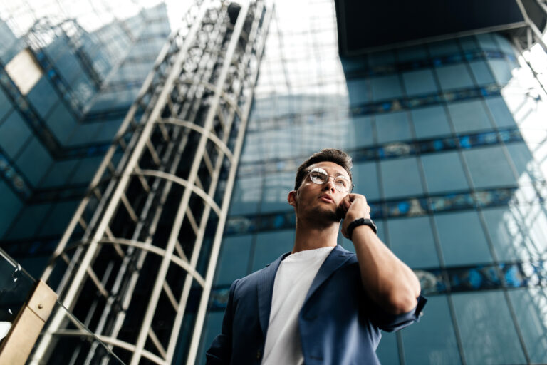Professional architect dressed in stylish clothes stands and talks by phone on the background of a