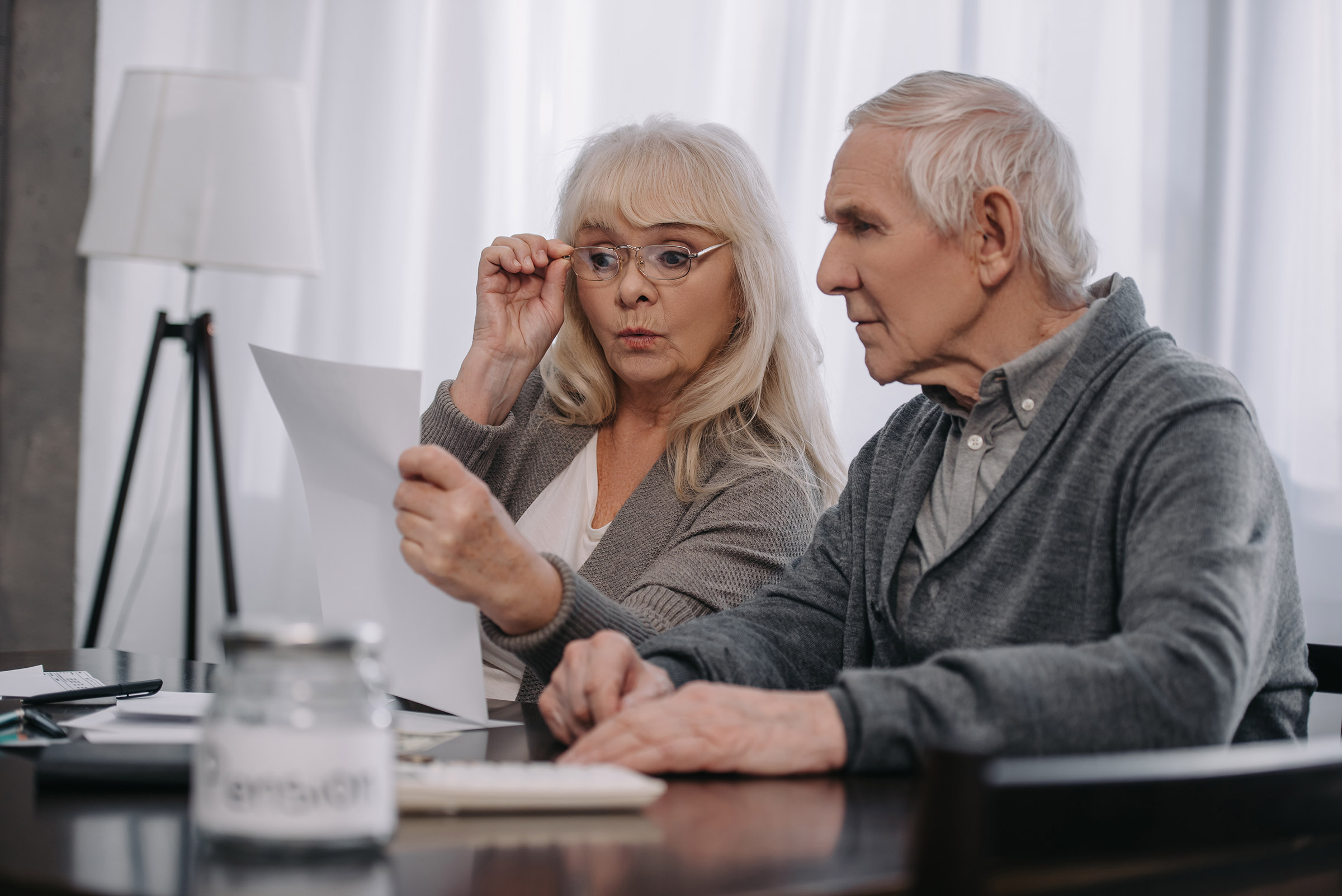 Surprised senior couple looking at billing statement