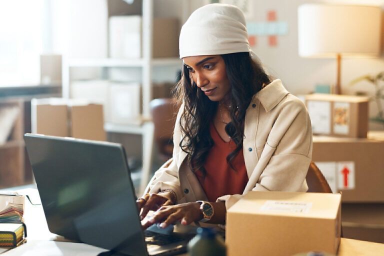 Woman, laptop and typing in small business logistics for order, ecommerce or design at boutique.