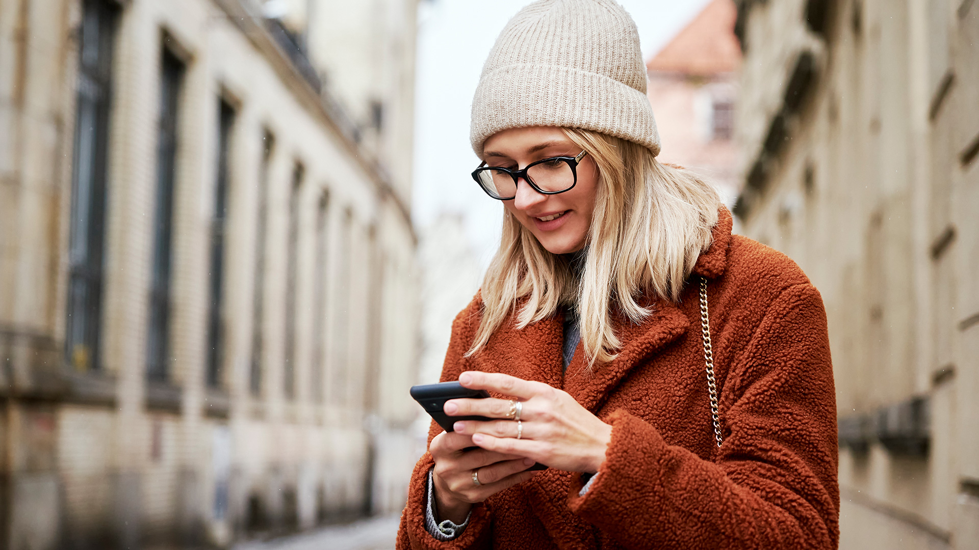 Woman her phone on a city street while traveling