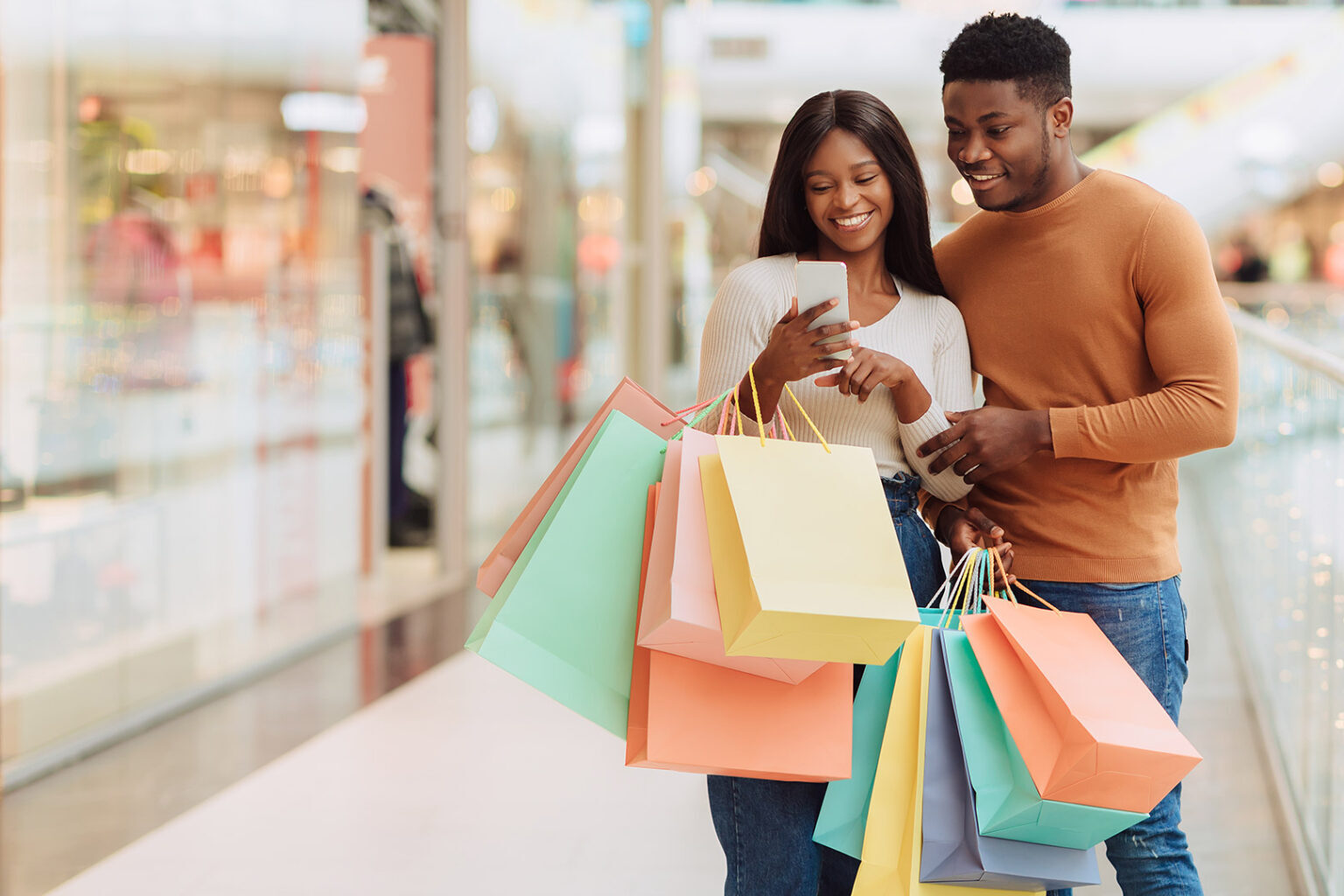 Young African American couple shops using phone