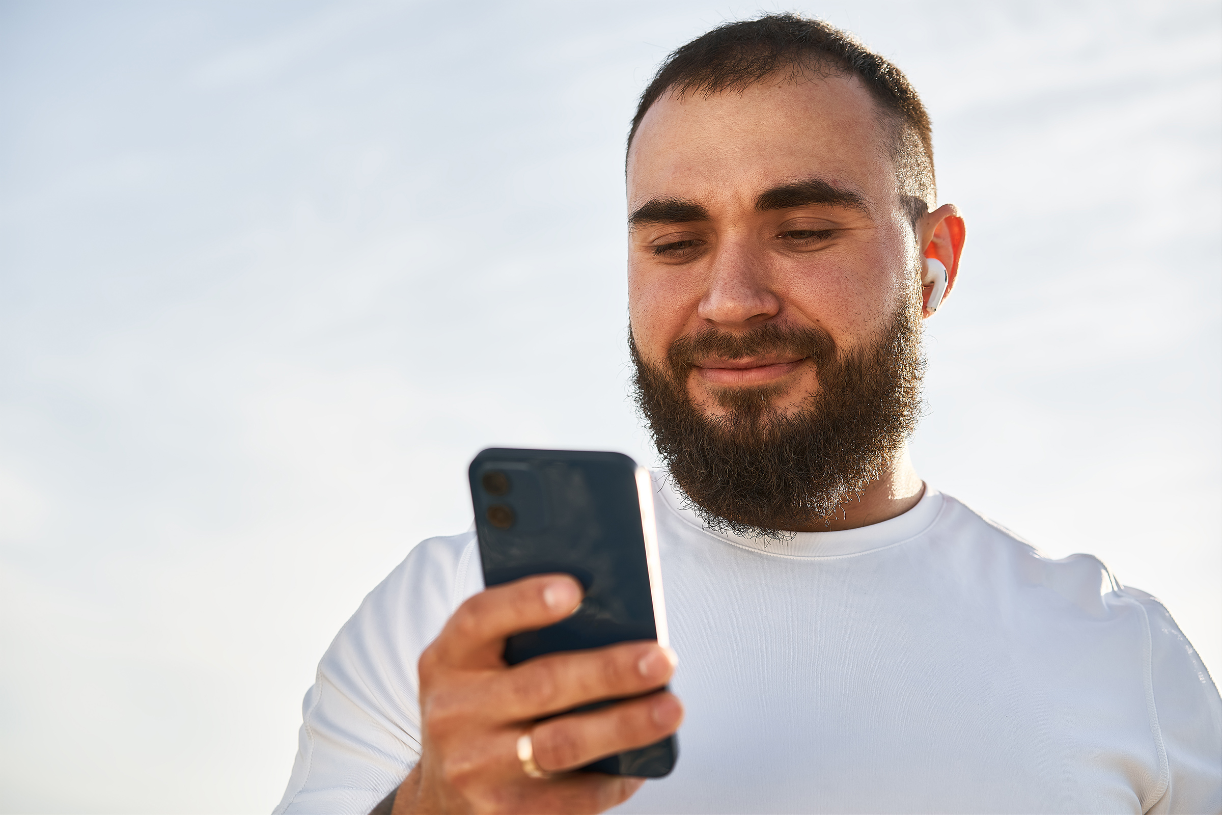 Young male using cell telephone while having a walk in countryside