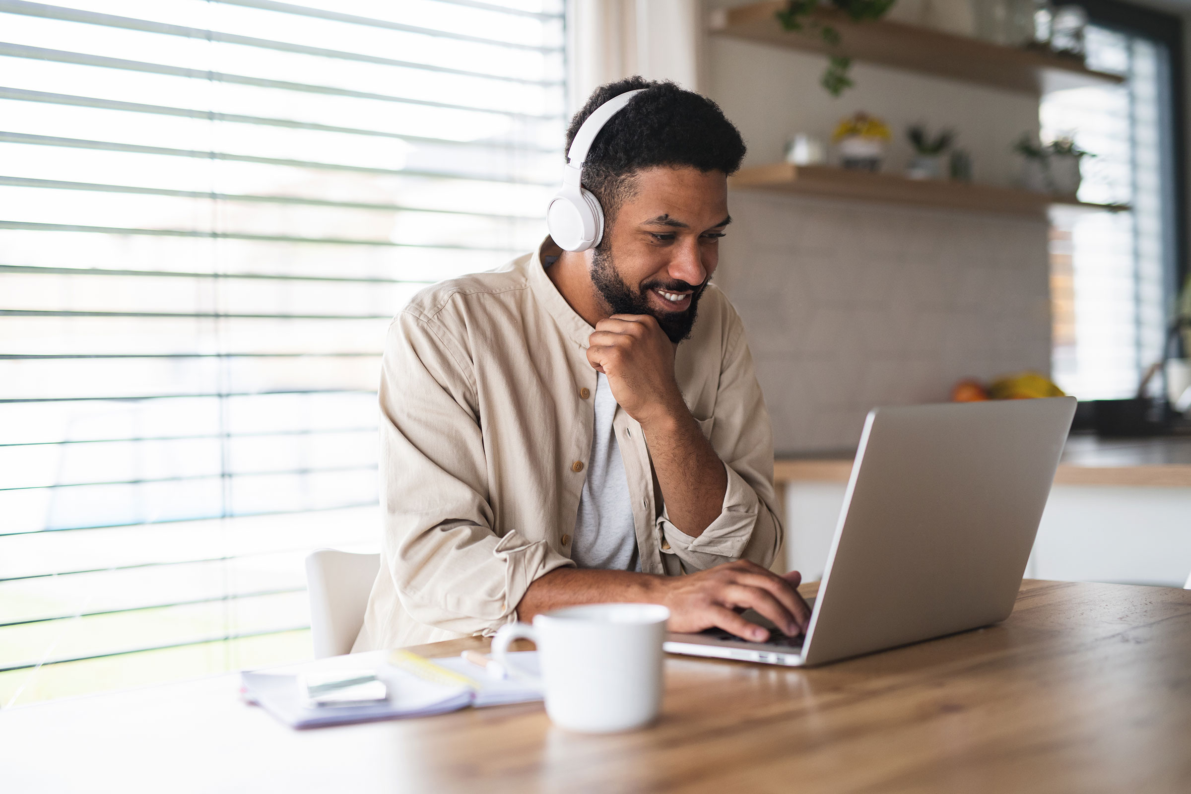 Young man sitting at laptop with headphones