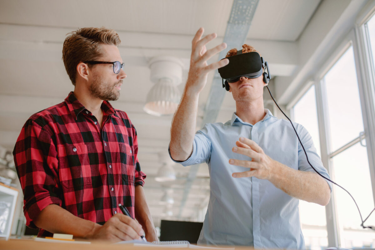 Shot of two young men testing virtual reality headset. 